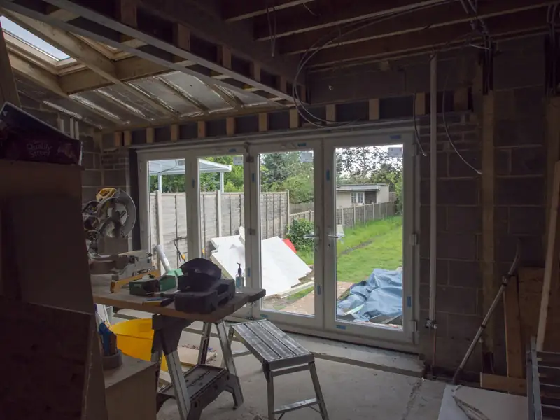 Pièce en chantier ouverte sur le jardin par une baie vitrée