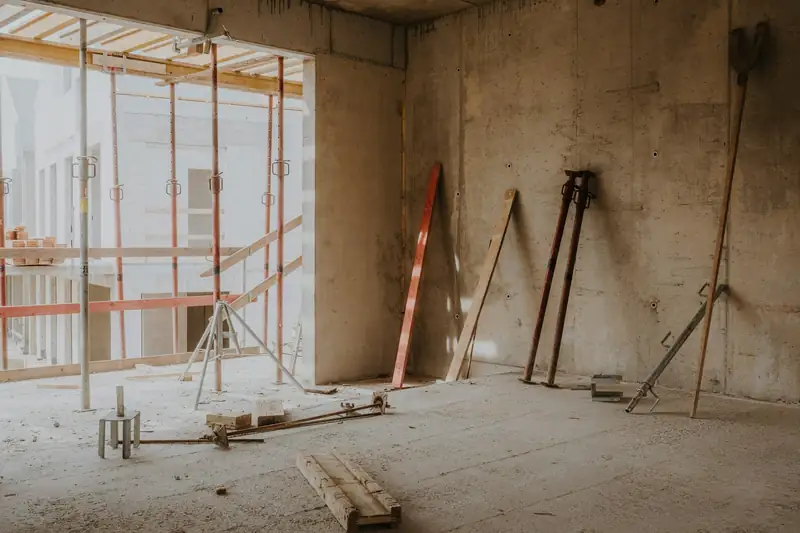 Grande pièce en chantier, échafaudage et étais le long d’un mur mis à nu