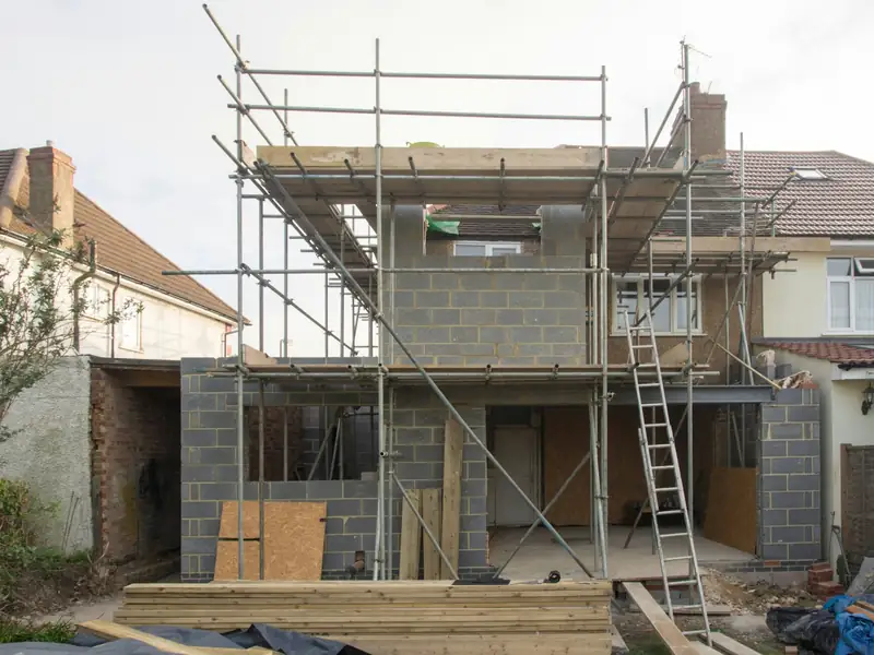 Extension en blocs béton sous échafaudage, à l’arrière d’une maison