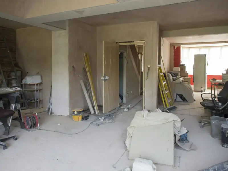 Pièce de maison en plein chantier : outils, matériaux et cloisons ouvertes