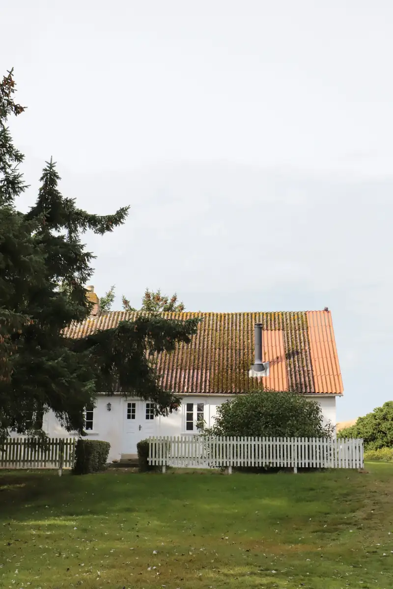 Maison enduite de blanc sous un toit de tuiles orangées